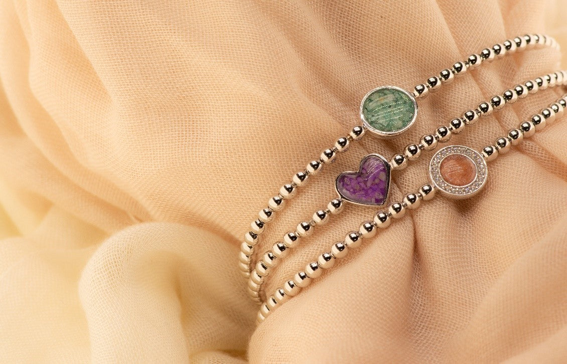 Flexibele as armband met rondje als compartiment gezet rondom met zirconia's voor as of haar. Alle