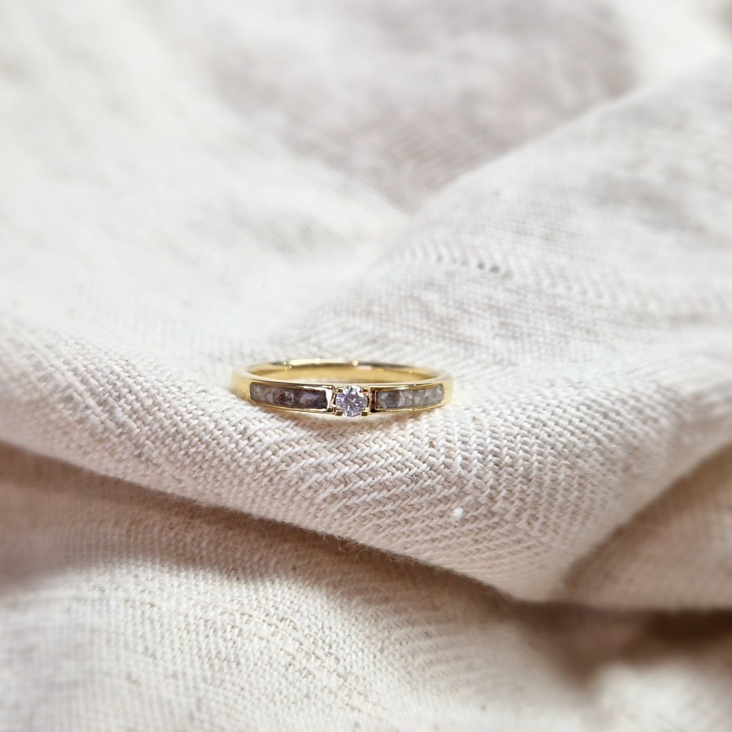 Gedenksieraad, ring 3 mm met (zirkonia of diamant), geflankeerd door twee compartimenten waar zichtbaar as of haar in verwerkt wordt. Alle