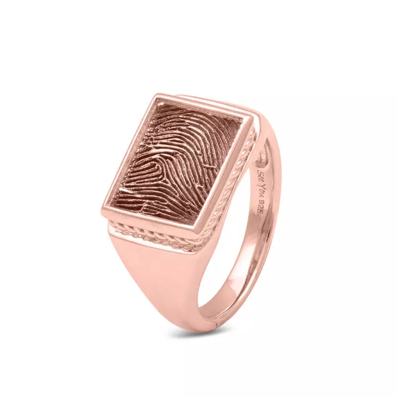 Zegelring met een rechthoekig vlak aan de voorzijde voorzien van een vingerafdruk.  Het is een tijdloos gedenksieraad en is te bestellen in zilver, 14 en 18 KT geelgoud,roségoud en witgoud. Er kan eventueel ook nog iets gegraveerd worden aan de binnenzijde van de ring.