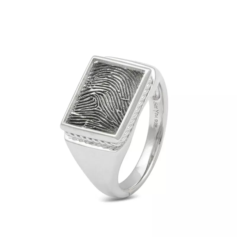 Zegelring met een rechthoekig vlak aan de voorzijde voorzien van een vingerafdruk.  Het is een tijdloos gedenksieraad en is te bestellen in zilver, 14 en 18 KT geelgoud,roségoud en witgoud. Er kan eventueel ook nog iets gegraveerd worden aan de binnenzijde van de ring.
