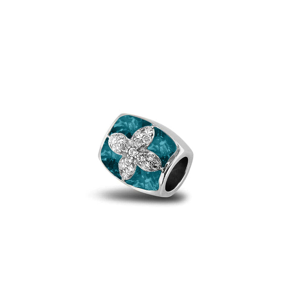 Asbedel met  zirkonia's, aan beide zijdes in twee compartimenten zichtbaar gevuld met as of haar. Turquoise