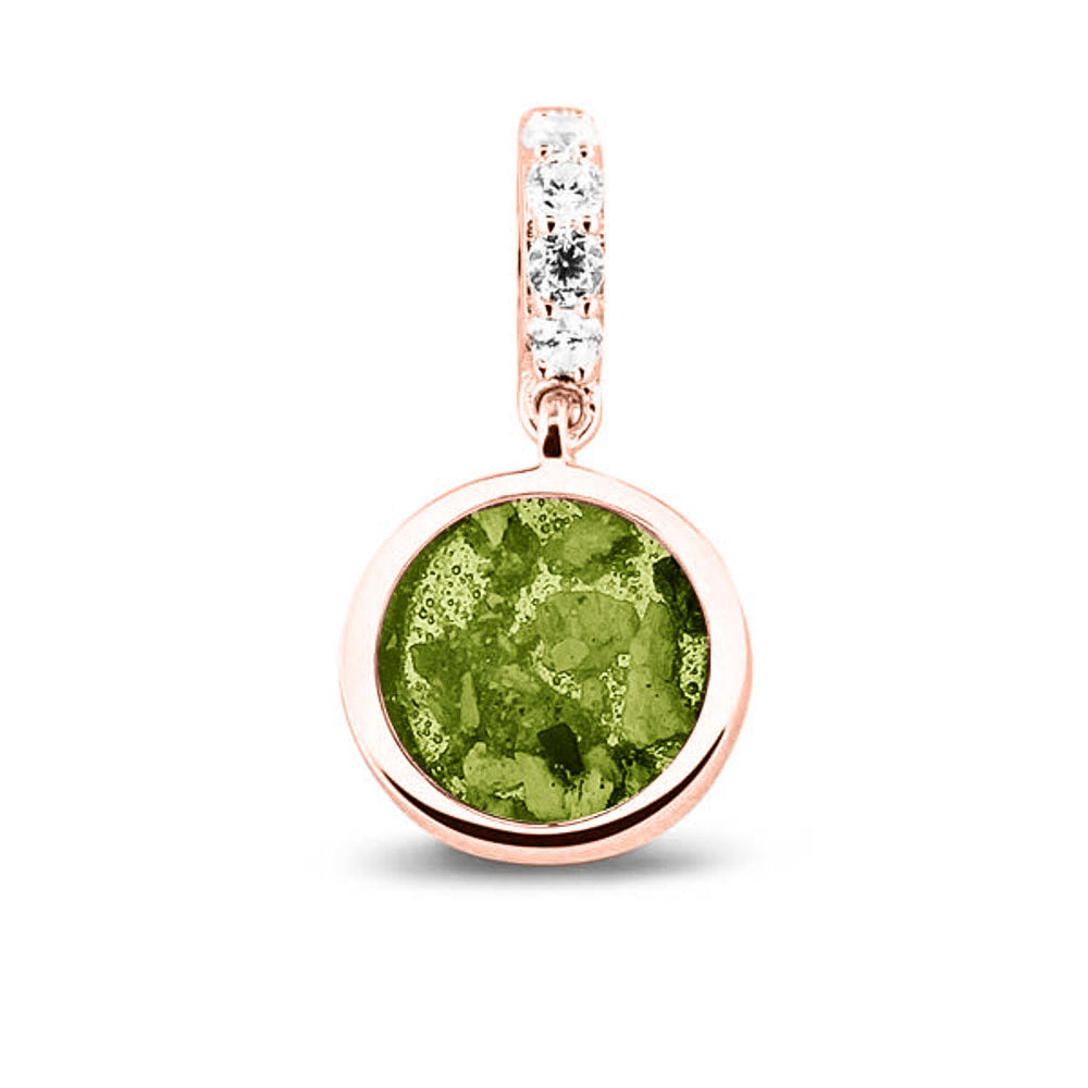 Asbedel rond subtiel design , het hangoog aan de buitenrand afgewerkt met zirkonia's, die aan de voorzijde zichtbaar gevuld wordt met as of haar met een keuze in 20 kleuren. Green