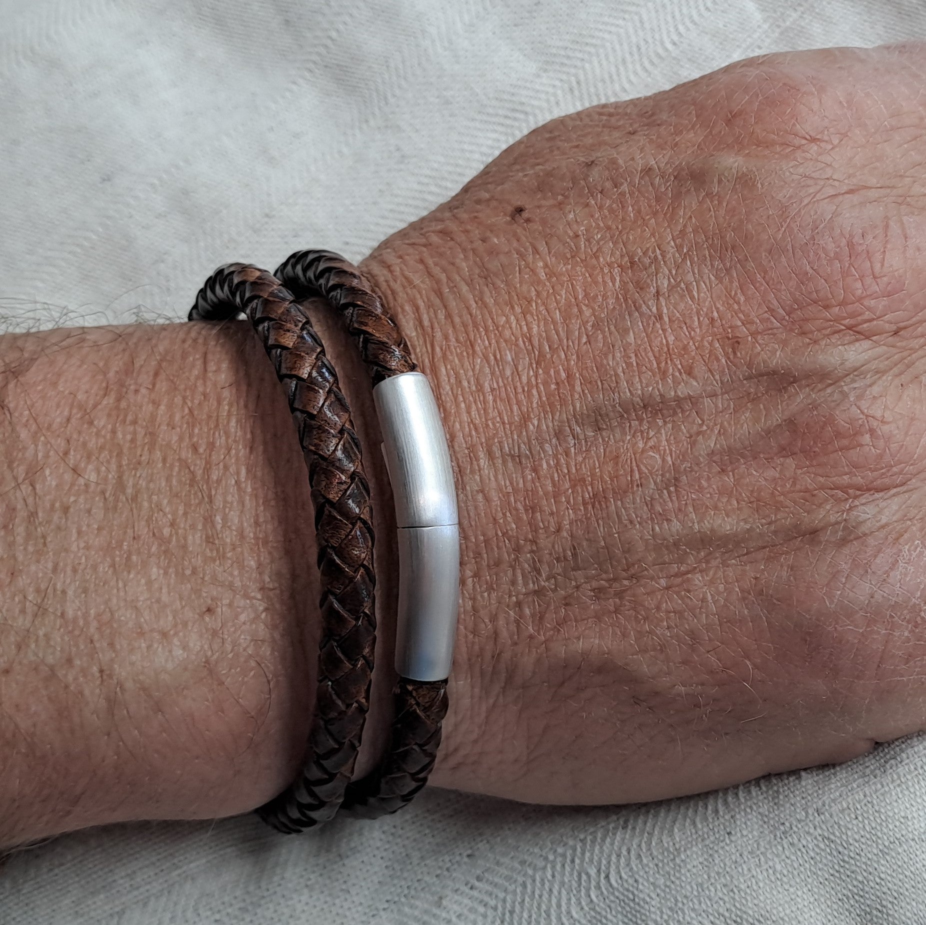 De lederen armband is voorzien van een 925 sterling zilveren sluiting en voorzien van een klein askamertje.alle
