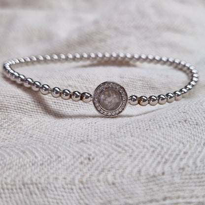 Flexibele as armband met rondje als compartiment gezet rondom met zirconia's voor as of haar. Alle