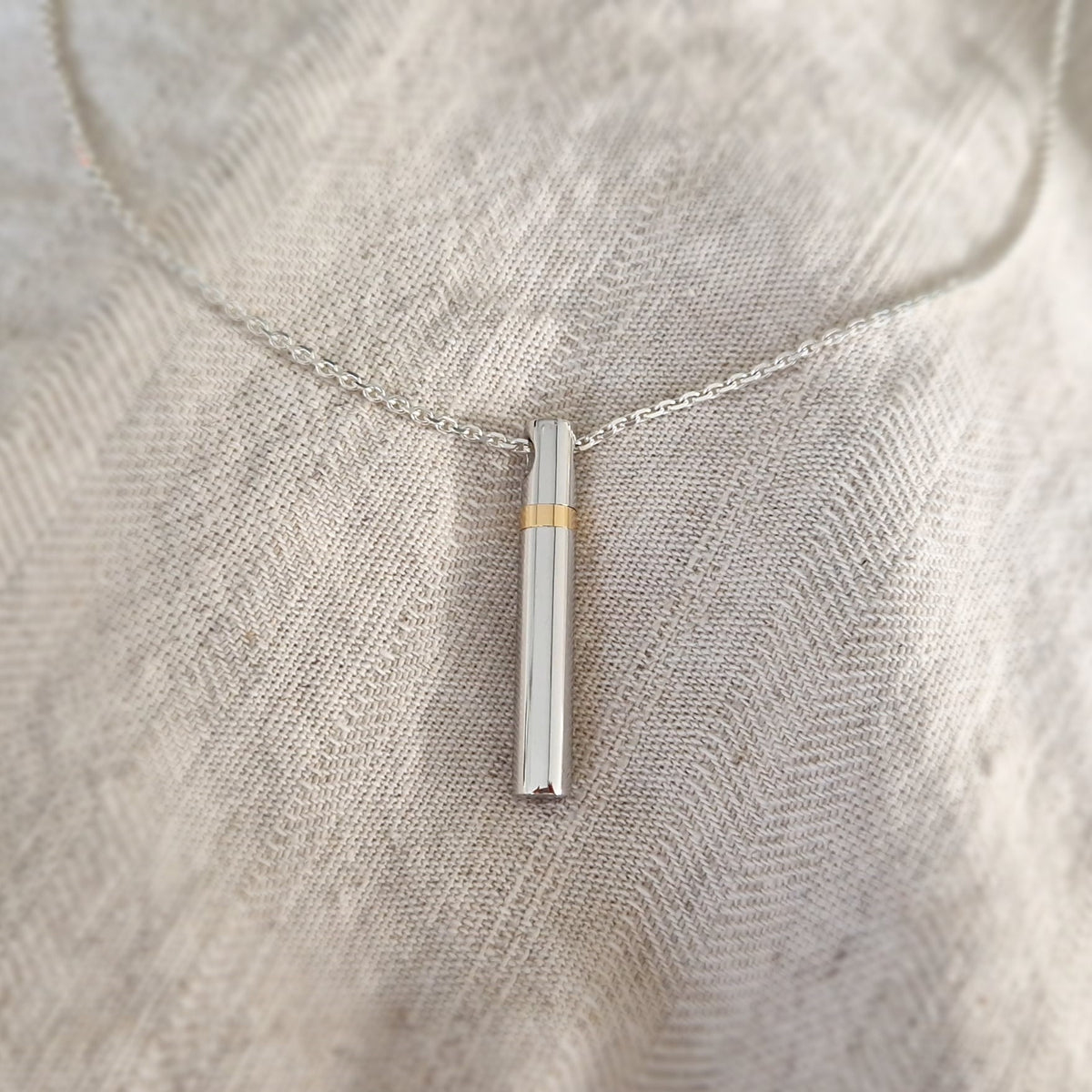 Hanger in buisvorm , de sluitring is gemaakt van 14 KT goud. De ashangers uit deze collectie gedenksieraden zijn zelf te vullen en te bestellen in zilver 925 sterling, geelgoud en witgoud.