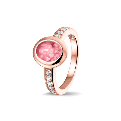 Gedenksieraad, ring 3 mm waar aan de ovale bovenzijde zichtbaar as of haar verwerkt wordt. In de bovenste helft van de ringband zijn zirkonia's of diamanten naar keuze gezet. Soft