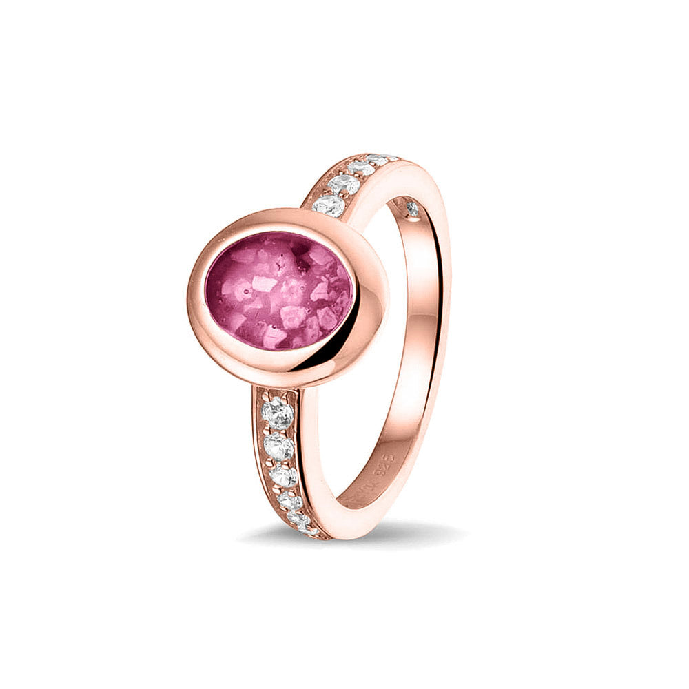 Gedenksieraad, ring 3 mm waar aan de ovale bovenzijde zichtbaar as of haar verwerkt wordt. In de bovenste helft van de ringband zijn zirkonia's of diamanten naar keuze gezet. Fluo