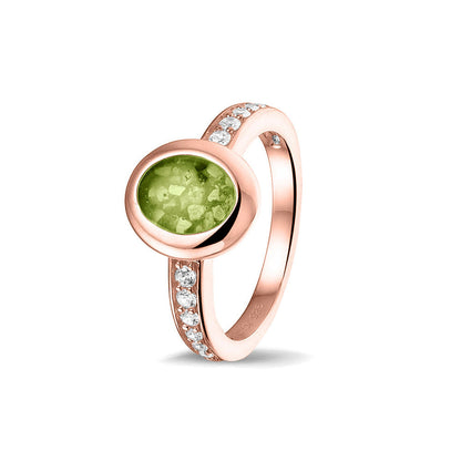 Gedenksieraad, ring 3 mm waar aan de ovale bovenzijde zichtbaar as of haar verwerkt wordt. In de bovenste helft van de ringband zijn zirkonia's of diamanten naar keuze gezet. Green