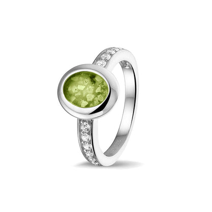 Gedenksieraad, ring 3 mm waar aan de ovale bovenzijde zichtbaar as of haar verwerkt wordt. In de bovenste helft van de ringband zijn zirkonia's of diamanten naar keuze gezet. Green