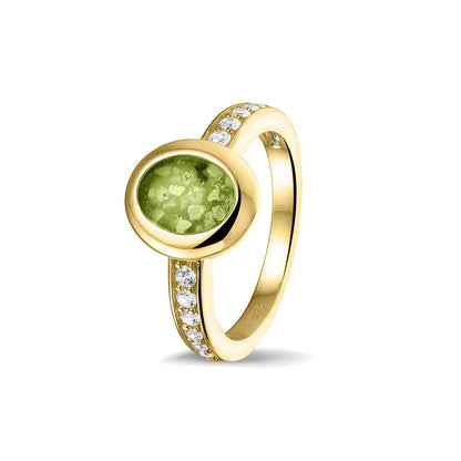 Gedenksieraad, ring 3 mm waar aan de ovale bovenzijde zichtbaar as of haar verwerkt wordt. In de bovenste helft van de ringband zijn zirkonia's of diamanten naar keuze gezet. Green