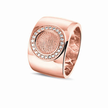 Ring 14 KT roségoud met rond vlak aan de bovenzijde voorzien van een vingerafdruk afgewerkt aan de randen met zirkonia's. Het is een tijdloos gedenksieraad.