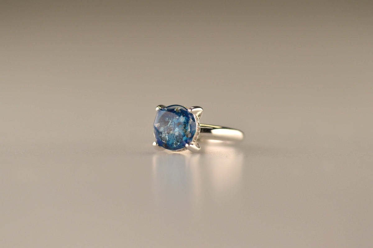 Gedenksieraad, asring 3 mm waar aan de bovenzijde zichtbaar as of haar verwerkt wordt, rondom aan de zijkant gezet met zirkonia's of diamanten naar keuze. 