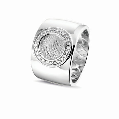 Ring 14 KT witgoud met rond vlak aan de bovenzijde voorzien van een vingerafdruk afgewerkt aan de randen met zirkonia's. Het is een tijdloos gedenksieraad.