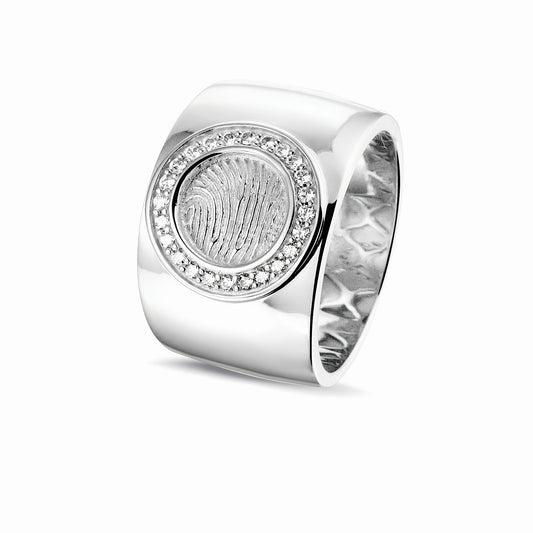 Ring 14 KT witgoud met rond vlak aan de bovenzijde voorzien van een vingerafdruk afgewerkt aan de randen met zirkonia's. Het is een tijdloos gedenksieraad.