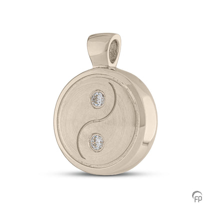 Yin yang hanger, dit sieraad beschikt over 2 askamers. In zilver uitgevoerd met zirkonia's, in goud met diamanten.