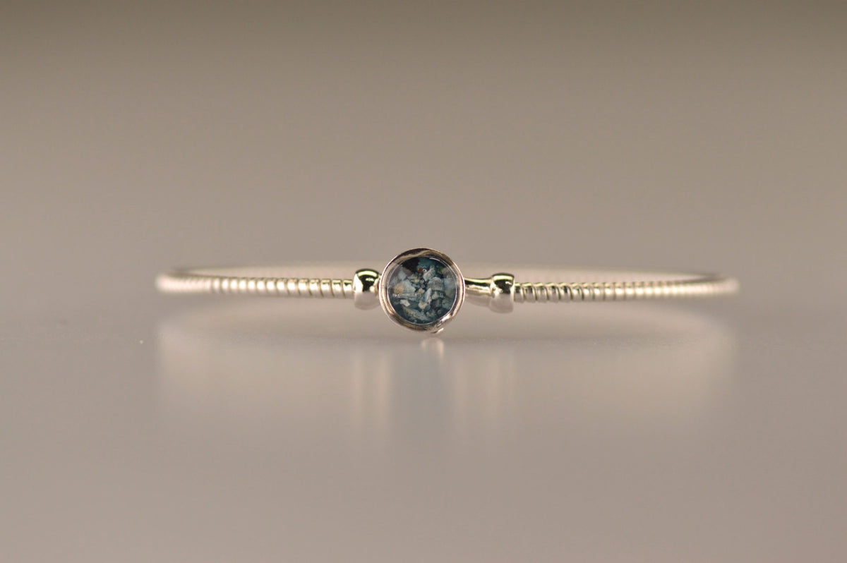 Zilveren as armband met in het midden een ornamentje, gedenksieraad, alle