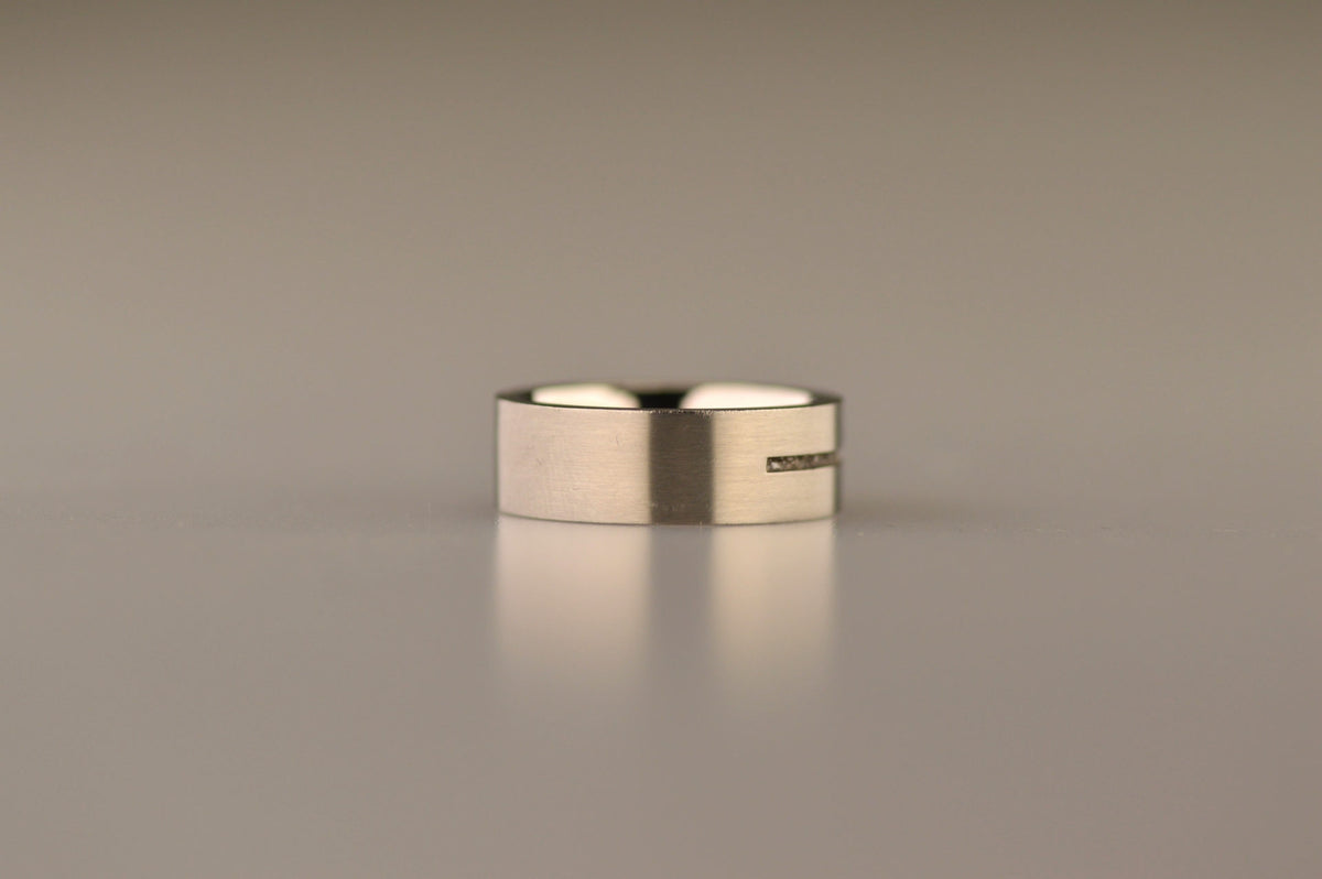 Ring als gedenksieraad 7 mm breed met één langwerpige streep waar as of haar  in verwerkt wordt.De asring is leverbaar in edelstaal, zilver en in 14 en 18 KT geelgoud/witgoud en roségoud. Alle